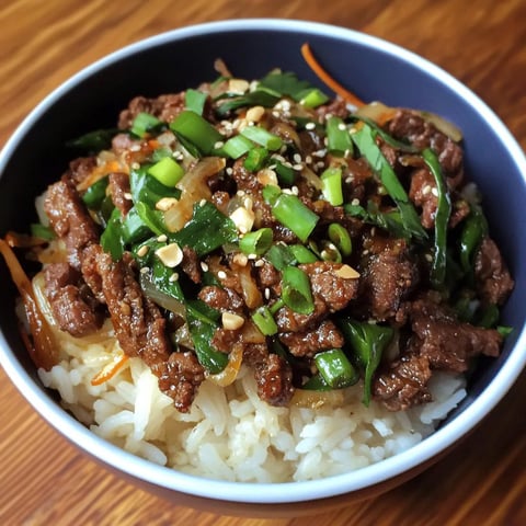 A bowl of beef and vegetables with rice.