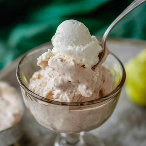 A glass of ice cream with a spoon in it.