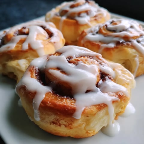 Three cinnamon rolls on a plate.